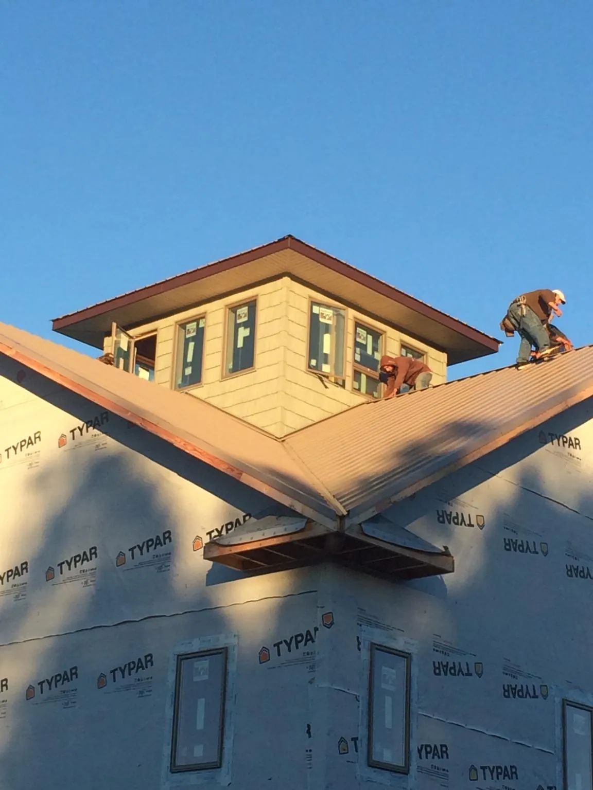 Roofers working around a rooftop cupola on a new metal roof at sunset — Roof Waterproofing in Raywood by Roofing Brothers